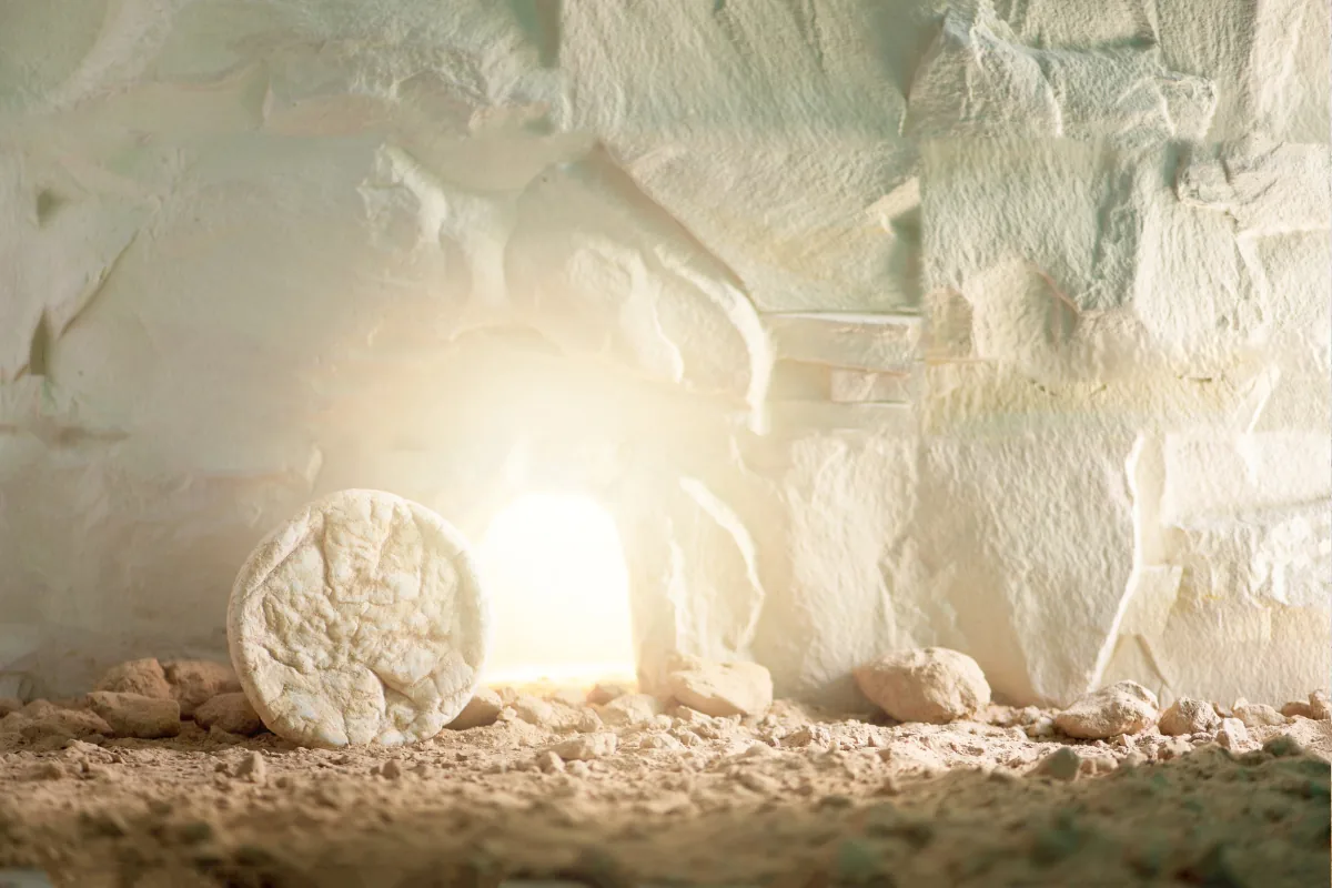 An empty tomb with the stone rolled away and bright light pouring out from within